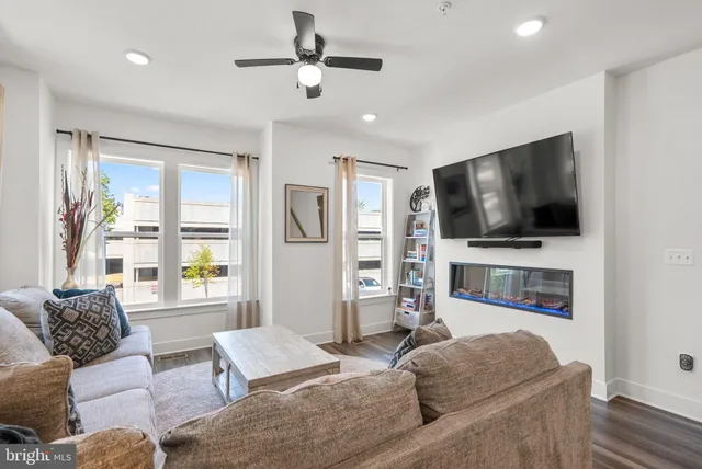 a living room with furniture and a view of kitchen