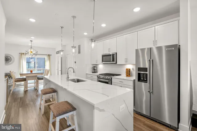 a kitchen with sink stove and wooden floor
