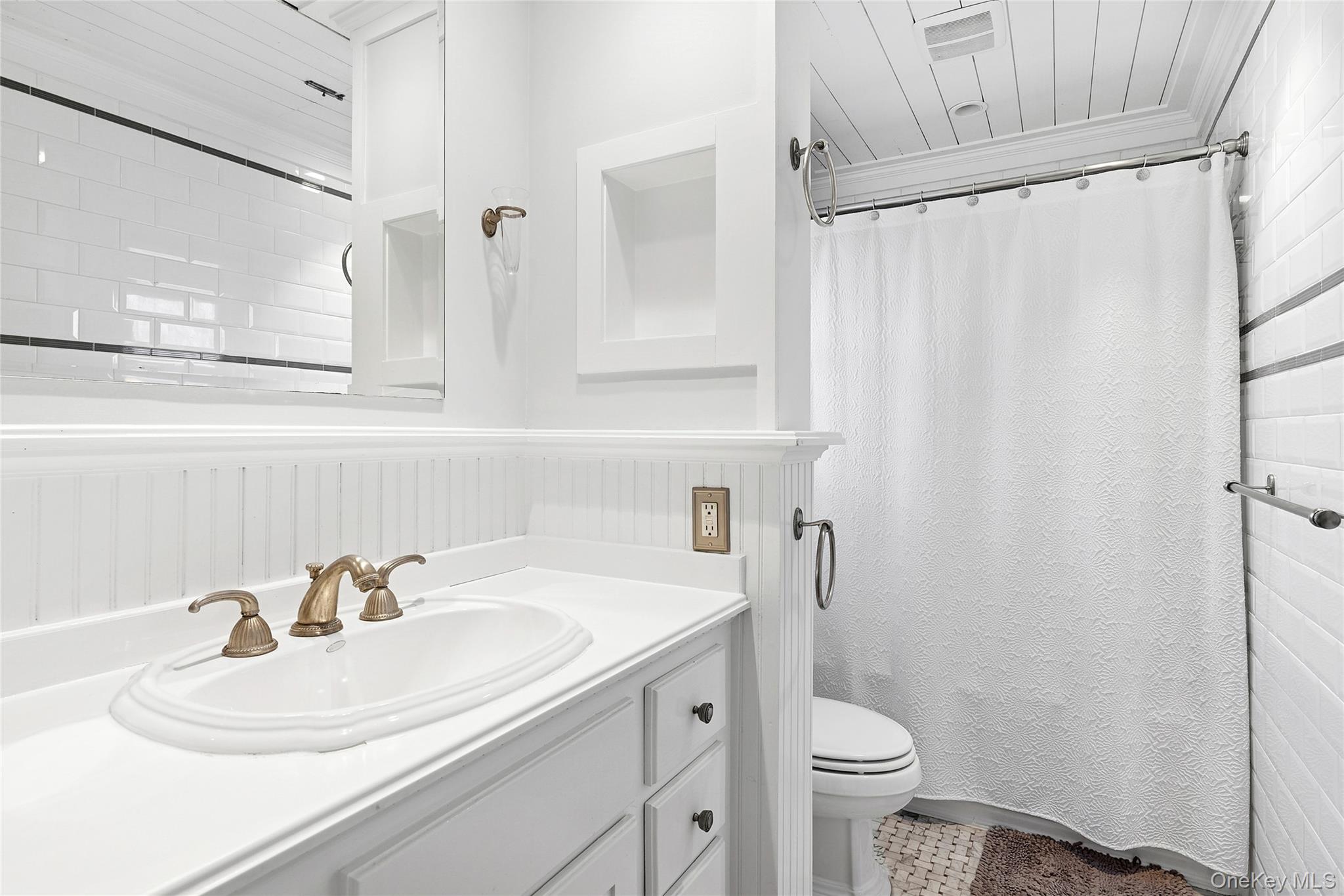 364 Three Mile Harbor Road East Hampton, NY 11937 - Photo 16 of 18 a bathroom with a sink a toilet and a mirror