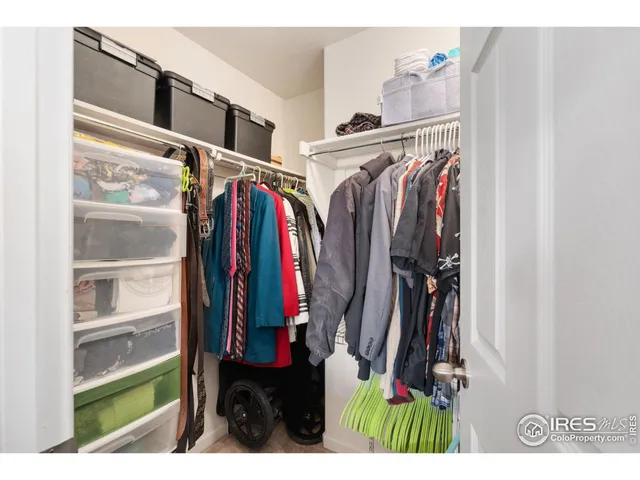 a view of walk in closet with clothes and shoes