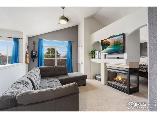 a living room with furniture a flat screen tv and a fireplace
