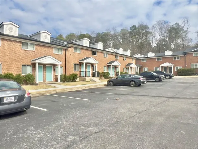 a front view of a house with a garden and parking