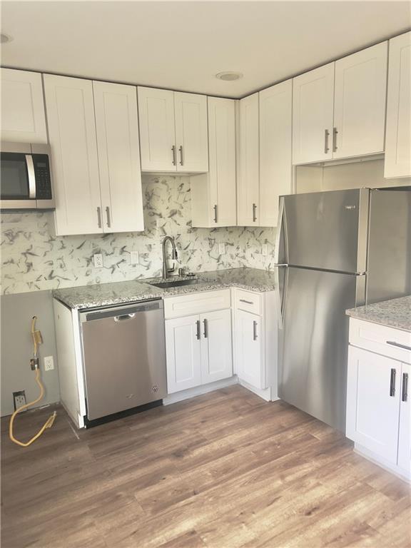 3781 Martin Luther King Junior Drive Southwest Atlanta, GA 30331 - Photo 8 of 13 a kitchen with a sink a refrigerator and white cabinets