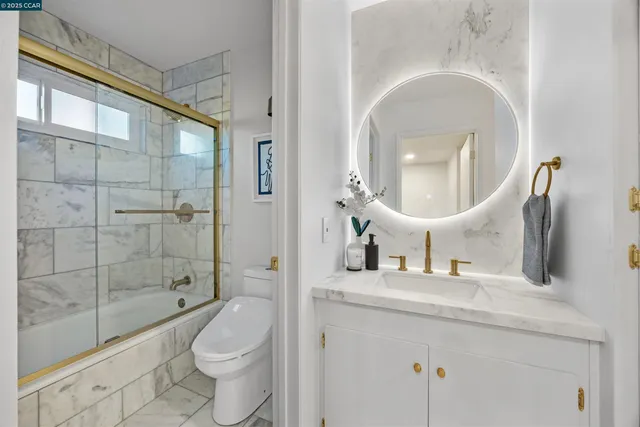 a bathroom with a toilet a sink and a large mirror