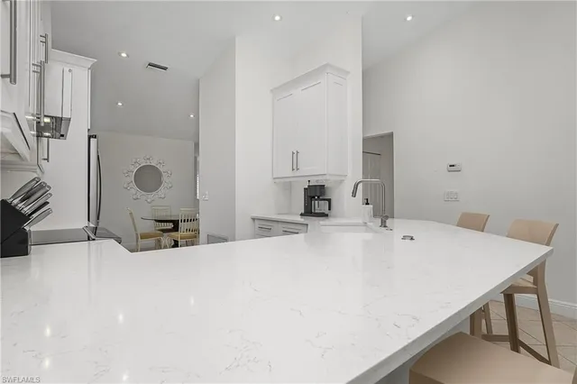 a kitchen with white cabinets stainless steel appliances and sink