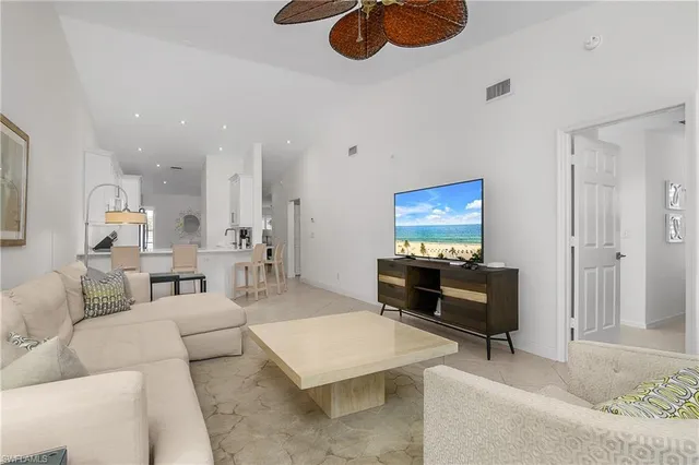 a living room with furniture kitchen view and a lamp