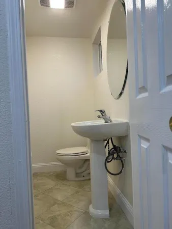 a bathroom with a sink a toilet and a mirror