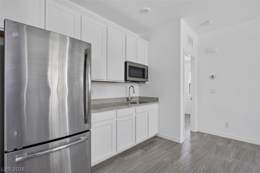 1824 Redland Ridge Street Henderson, NV 89002 - Photo 24 of 69 A compact kitchen area features stainless steel appliances and crisp white cabinetry.