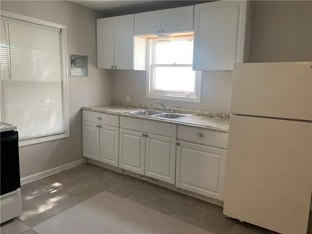 a kitchen with a white cabinets and a refrigerator