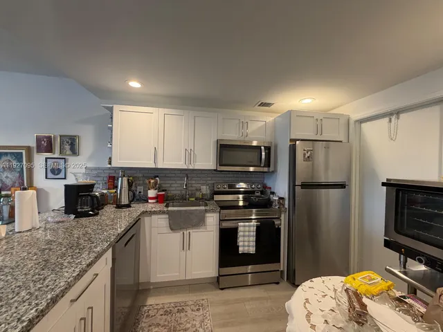 a kitchen with refrigerator a stove a sink dishwasher and microwave with wooden floor