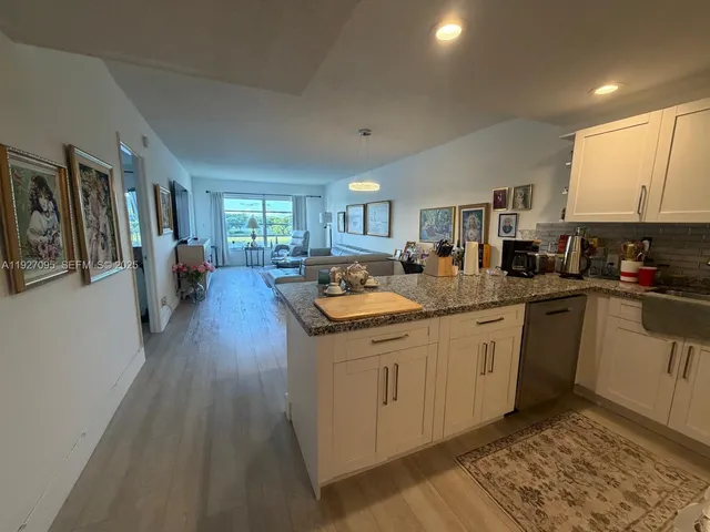 a kitchen with stainless steel appliances granite countertop a sink stove and wooden cabinets