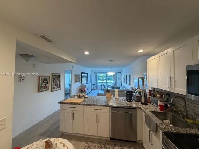 a kitchen with sink refrigerator and cabinets