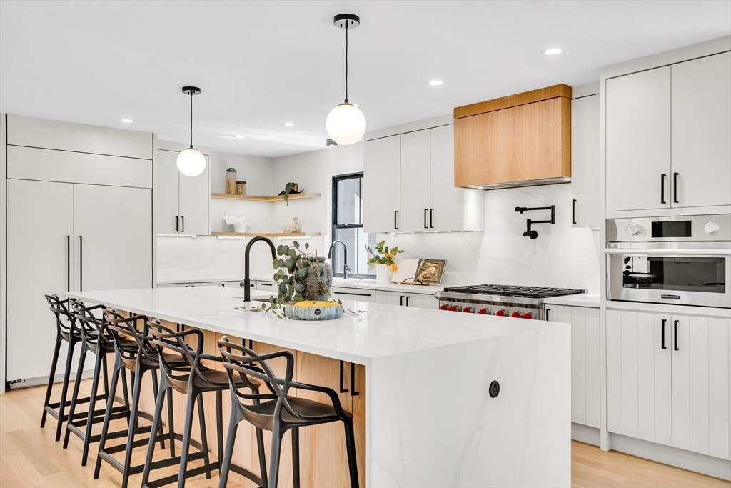 70 Birch Hill Road Belmont, MA 02478 - Photo 5 of 41 a kitchen with stainless steel appliances kitchen island granite countertop a stove a sink a refrigerator and white cabinets with wooden floor