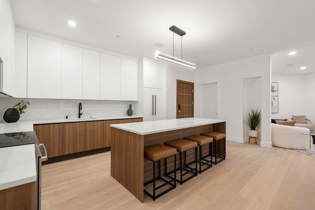 16 Stearns Road, Unit 304 Wellesley, MA 02482 - Photo 8 of 21 a kitchen with stainless steel appliances a sink stove and wooden floor