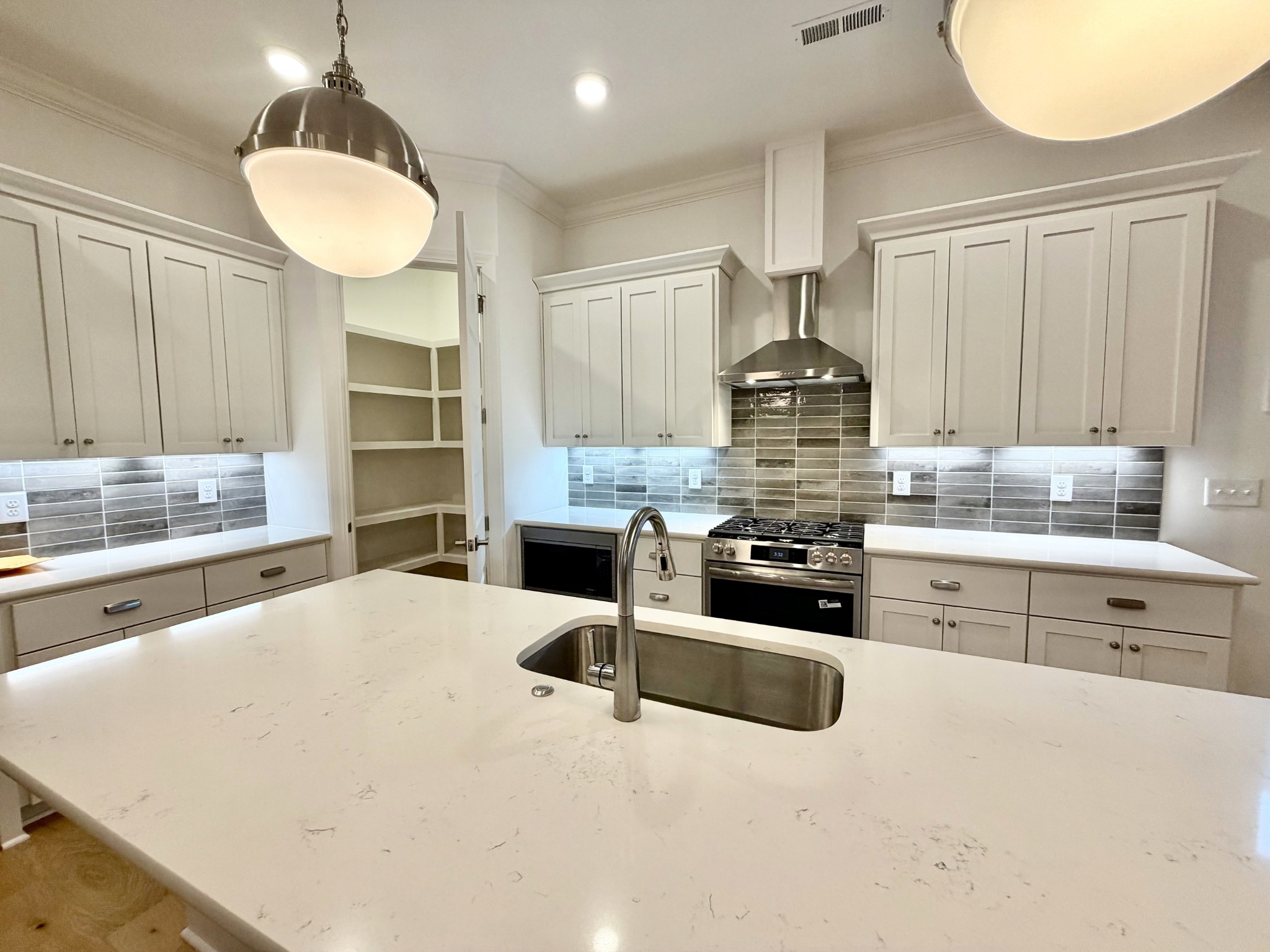 7137 Frances Street Fairview, TN 37062 - Photo 27 of 64 a kitchen with stainless steel appliances kitchen island granite countertop a stove and white cabinets