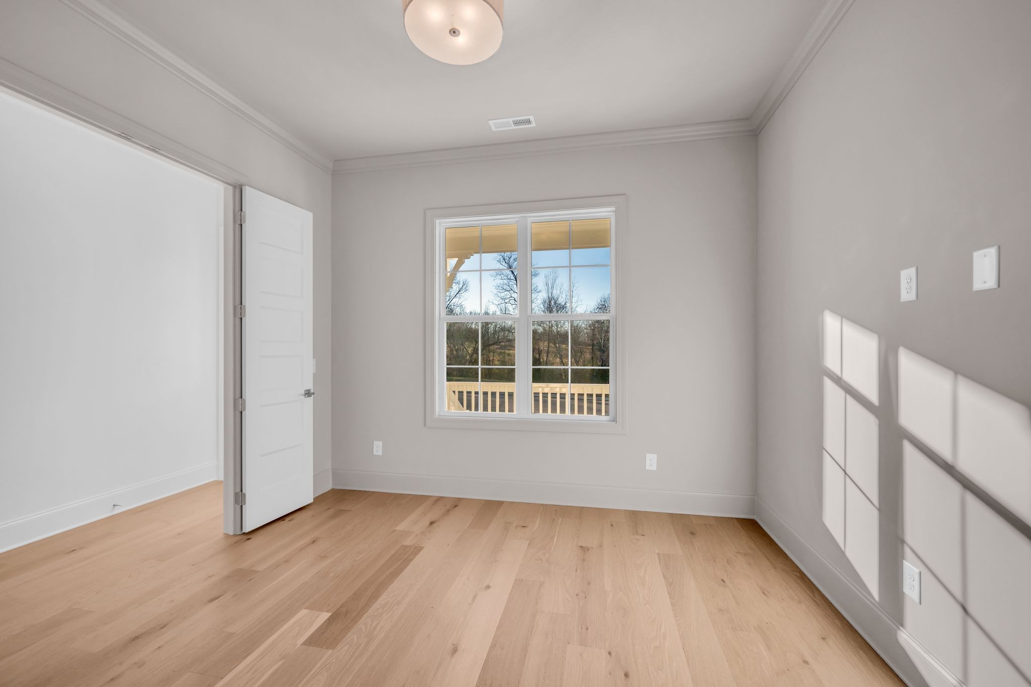 7137 Frances Street Fairview, TN 37062 - Photo 7 of 64 a view of an empty room with wooden floor and a window