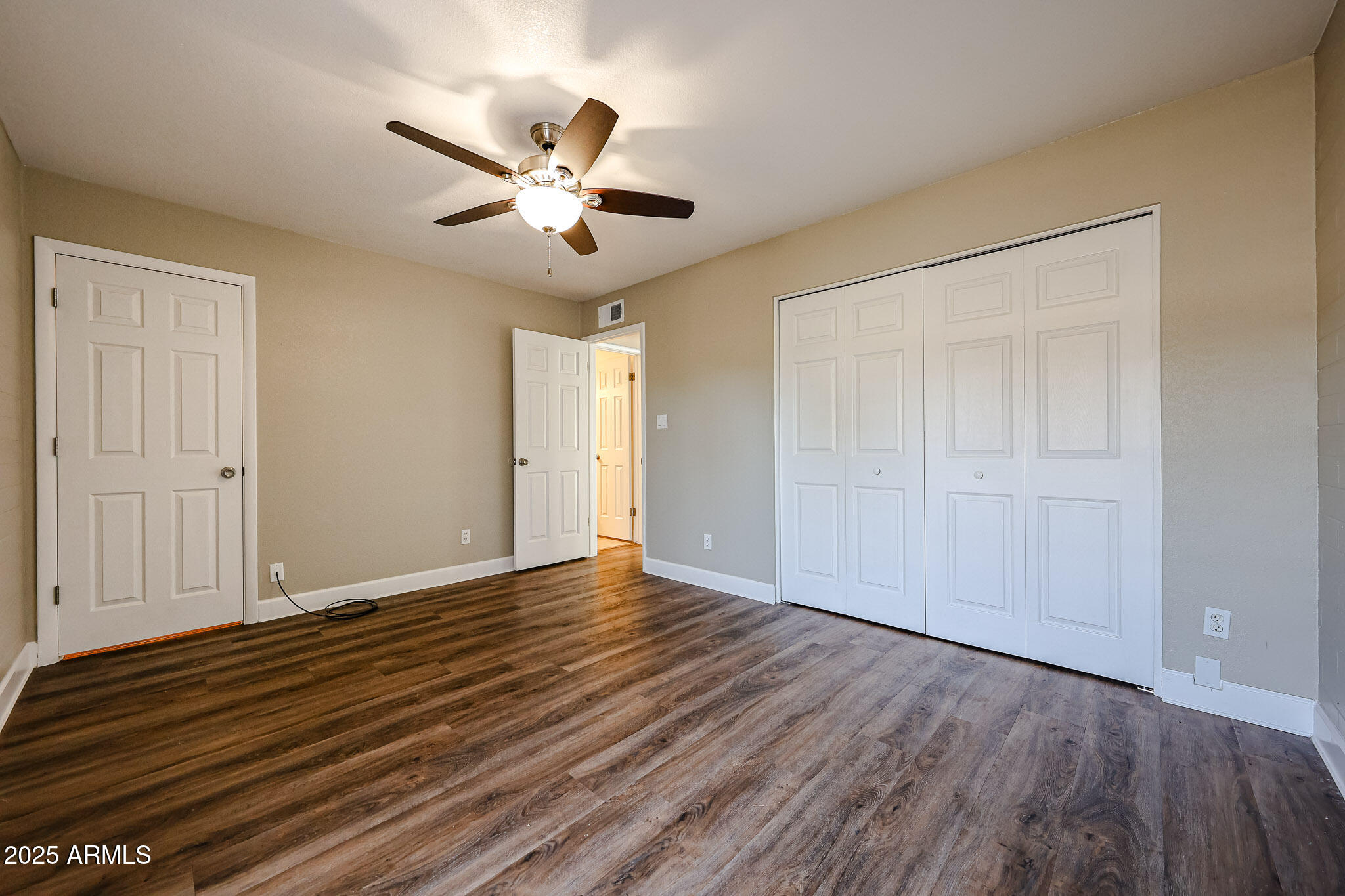 4419 North 27th Street, Unit 22 Phoenix, AZ 85016 - Photo 22 of 46 a view of an empty room with wooden floor and a ceiling fan