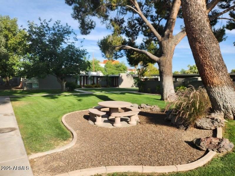 4419 North 27th Street, Unit 22 Phoenix, AZ 85016 - Photo 32 of 46 a view of a backyard with table and chairs potted plants and large tree