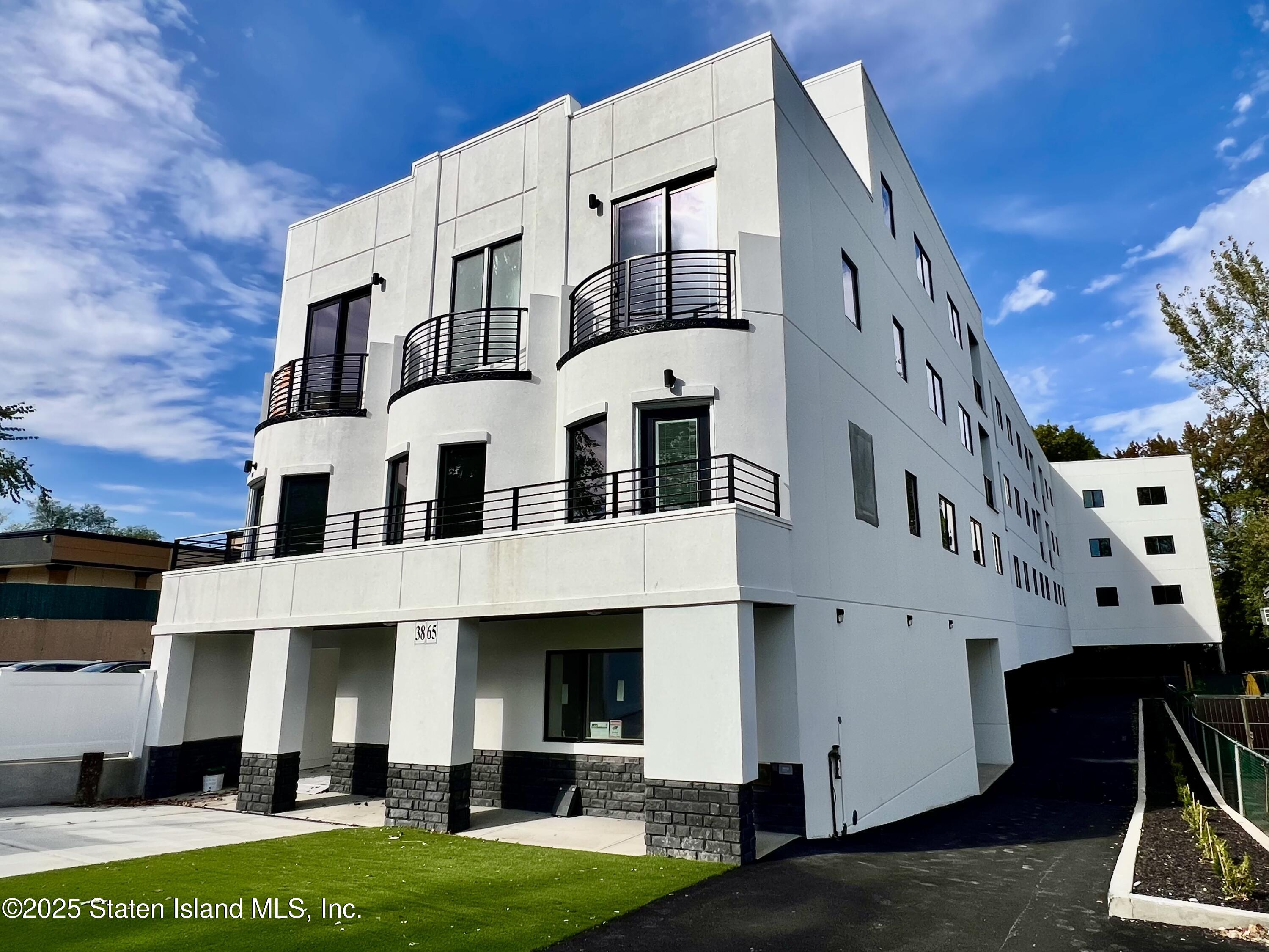 3865 Amboy Road, Unit 4A Staten Island, NY 10308 - Photo 4 of 18 a front view of a building with a garden