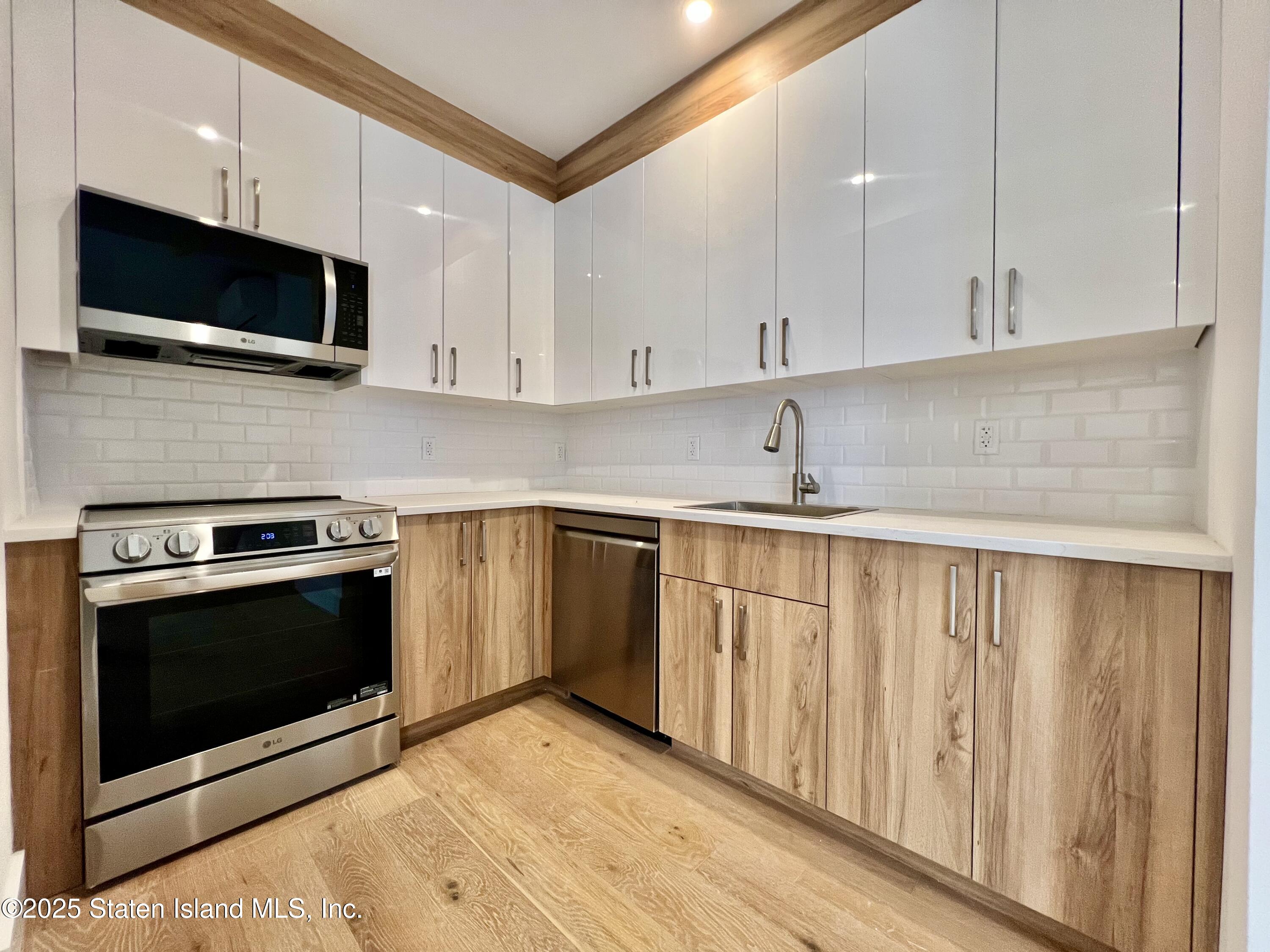 3865 Amboy Road, Unit 4A Staten Island, NY 10308 - Photo 7 of 18 a kitchen with stainless steel appliances granite countertop a sink a stove a microwave and cabinets