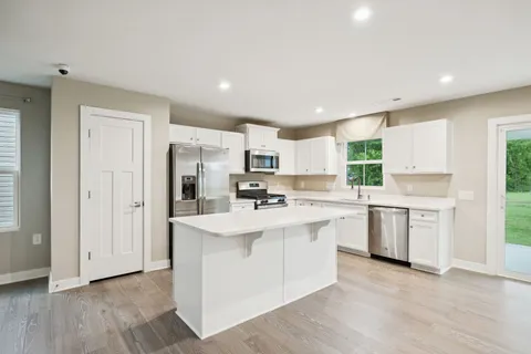 a kitchen with white cabinets and white appliances