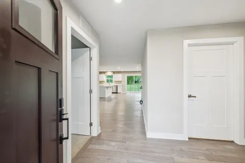a view of a hallway with wooden floor and closet
