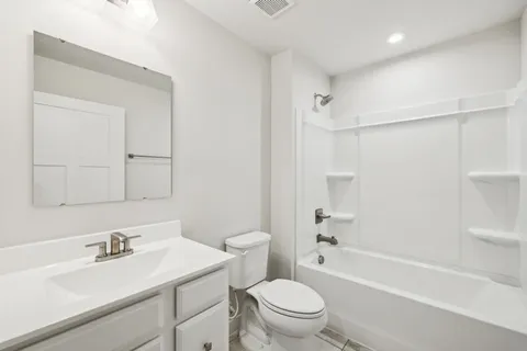 a bathroom with a sink toilet vanity and shower