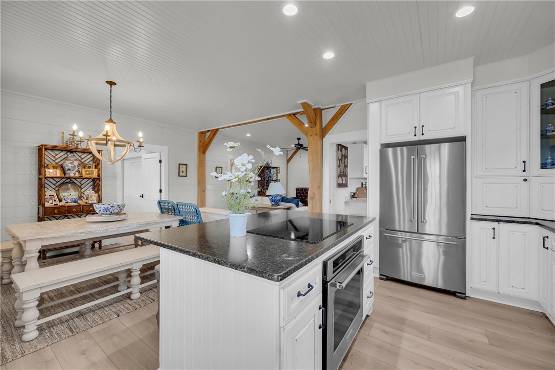 498 Raines Road Mountain Rest, SC 29664 - Photo 36 of 48 An open kitchen layout centers on a cooktop island beneath recessed lighting and planked ceilings.