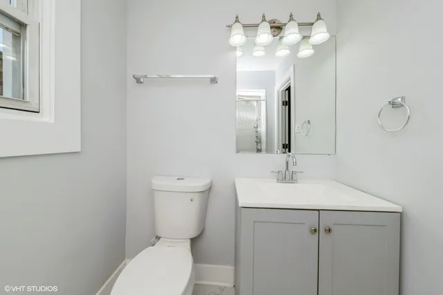 a bathroom with a toilet a sink and mirror