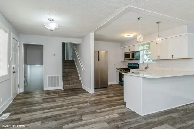 a kitchen with stainless steel appliances a refrigerator sink and microwave