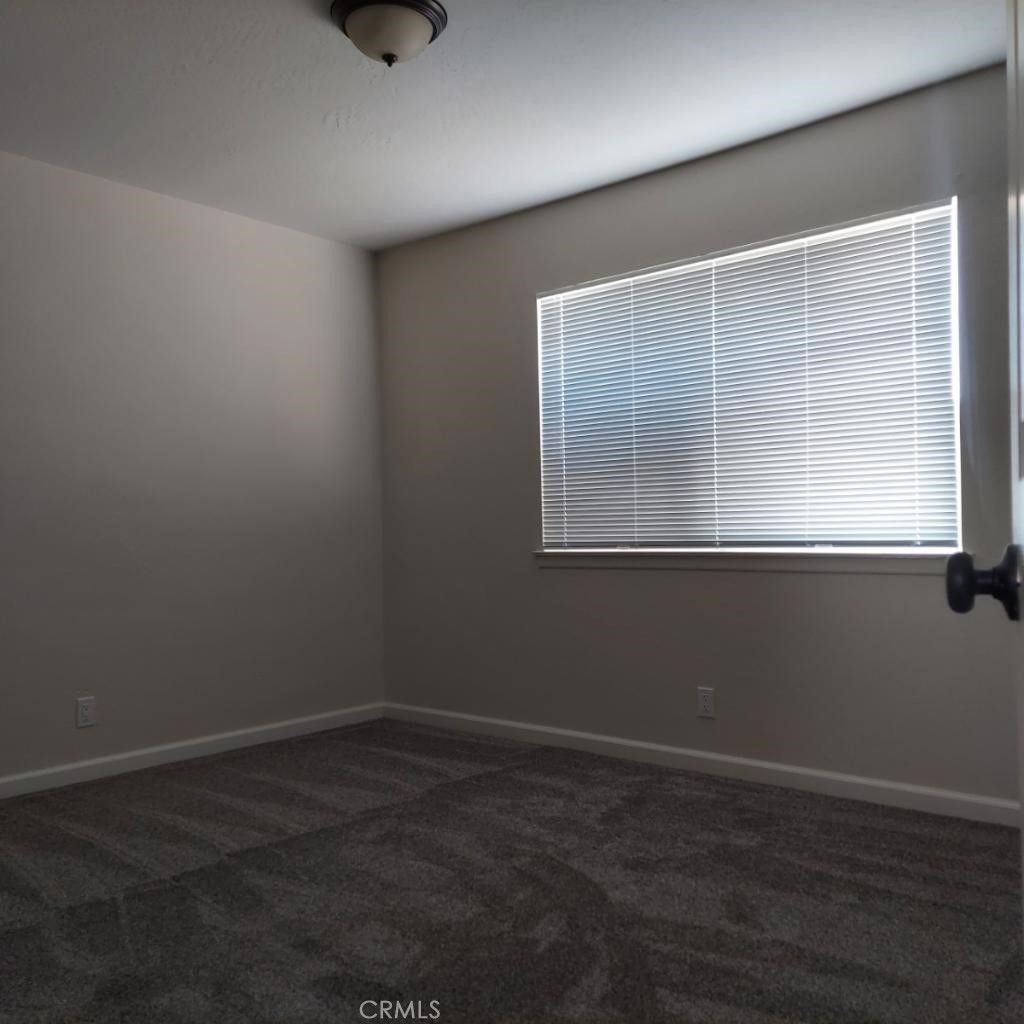 12754 Redwing Road Apple Valley, CA 92308 - Photo 3 of 9 a view of an empty room with wooden floor and a window