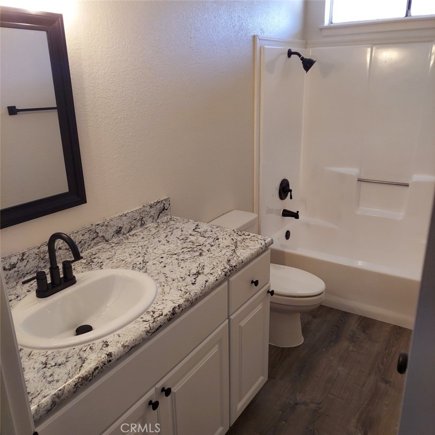 12754 Redwing Road Apple Valley, CA 92308 - Photo 5 of 9 a bathroom with a granite countertop sink a toilet and shower