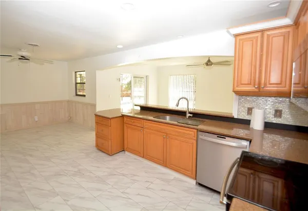 a kitchen with granite countertop a sink cabinets and wooden floor