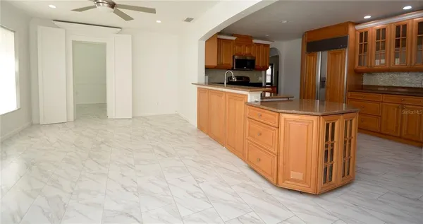 a view of a livingroom with wooden floor and a ceiling fan