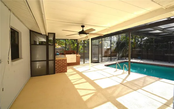 an empty room with wooden floor and a ceiling fan