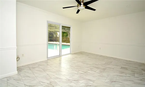 a view of a livingroom with a ceiling fan and window