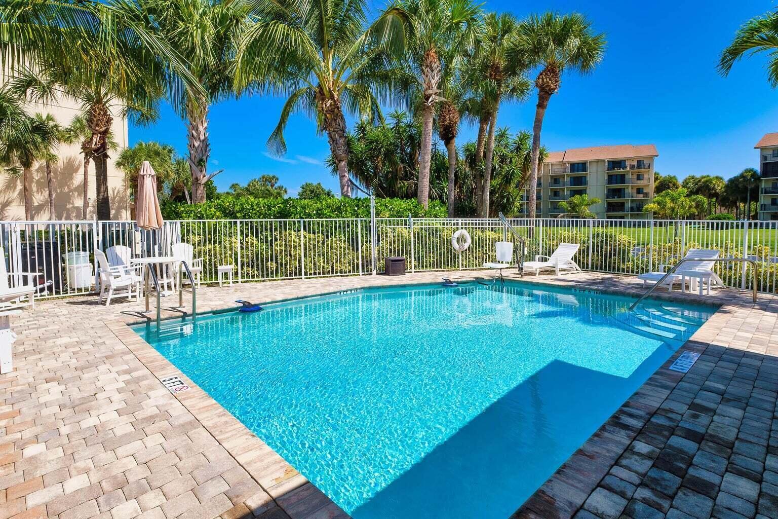 1320 Tidal Pointe Boulevard, Unit G12 Jupiter, FL 33477 - Photo 5 of 6 a view of a swimming pool with a patio and a garden