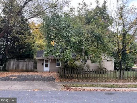 a view of a house with a fence and a tree