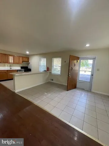 a view of a electric appliances in kitchen and empty room with windows
