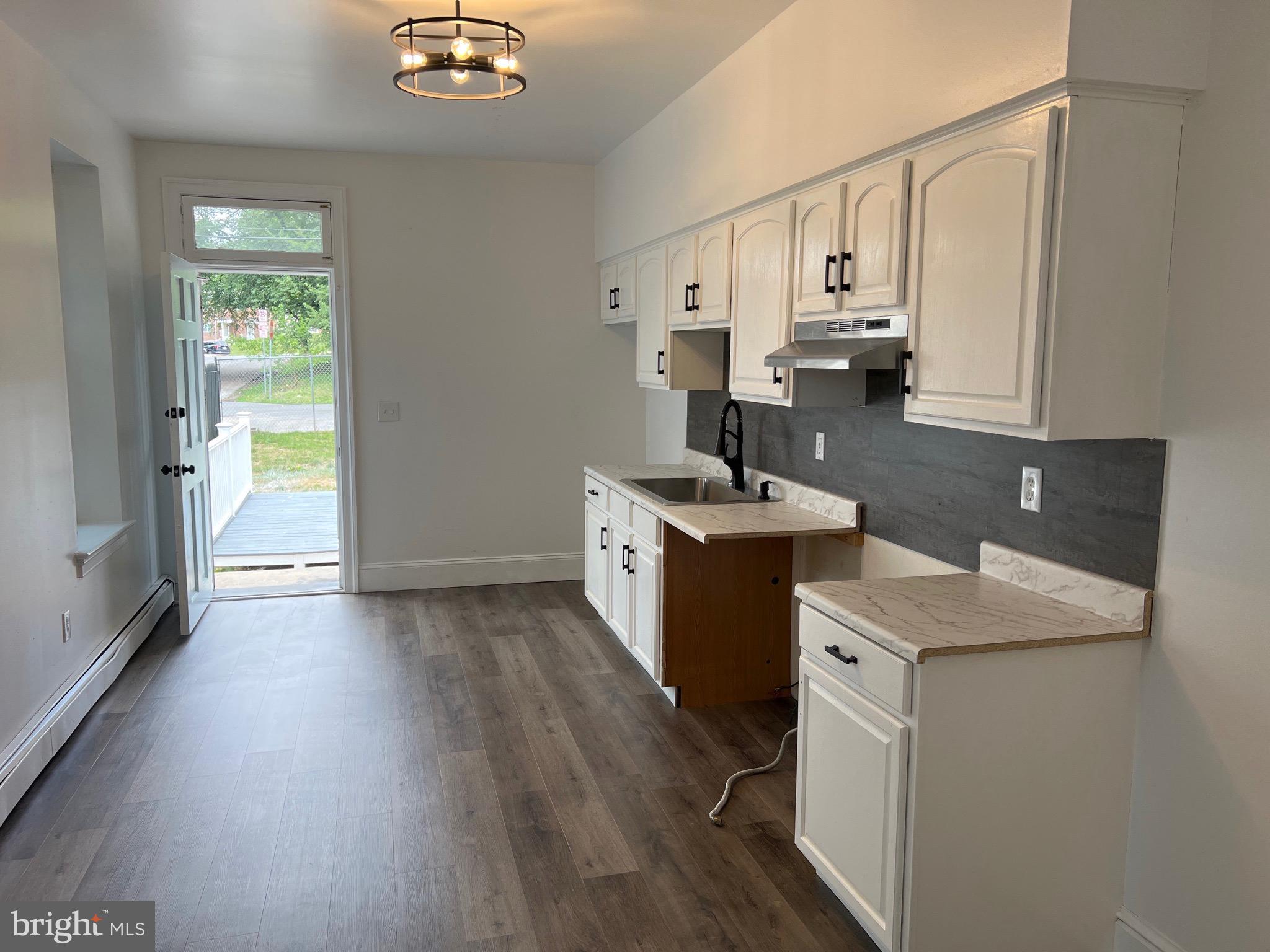 533 Thomas Street York, PA 17404 - Photo 7 of 26 a kitchen with a sink a stove cabinets and wooden floor