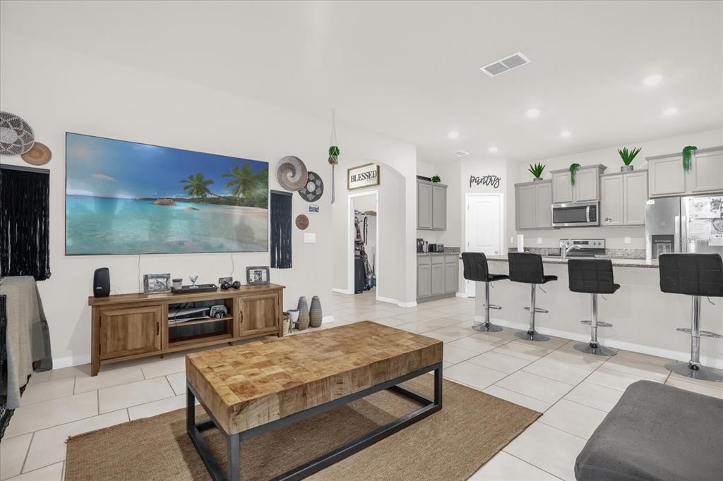 6775 Sarus Crane Point Harmony, FL 34773 - Photo 3 of 28 a living room with furniture a flat screen tv and kitchen view