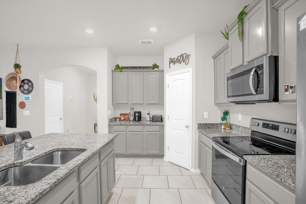 6775 Sarus Crane Point Harmony, FL 34773 - Photo 5 of 28 a kitchen with a sink stove top oven and refrigerator