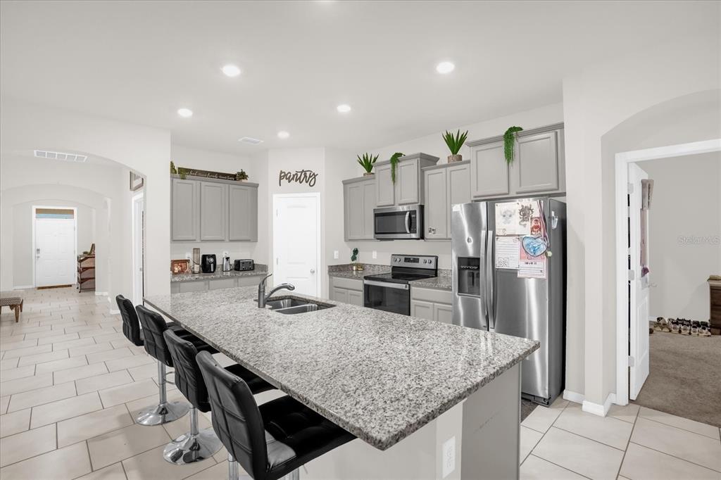 6775 Sarus Crane Point Harmony, FL 34773 - Photo 6 of 28 a kitchen with stainless steel appliances granite countertop sink refrigerator and microwave