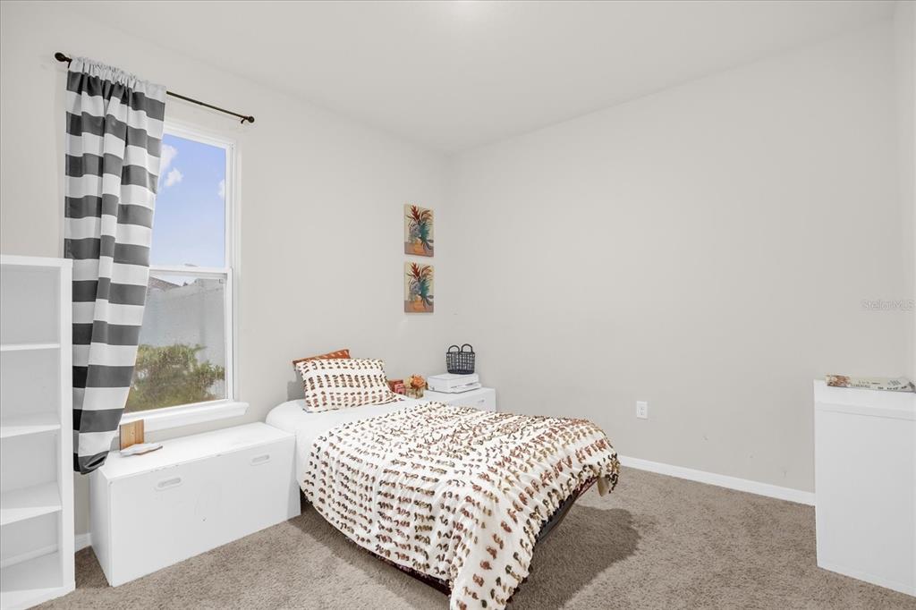 6775 Sarus Crane Point Harmony, FL 34773 - Photo 8 of 28 a bedroom with a bed and a window