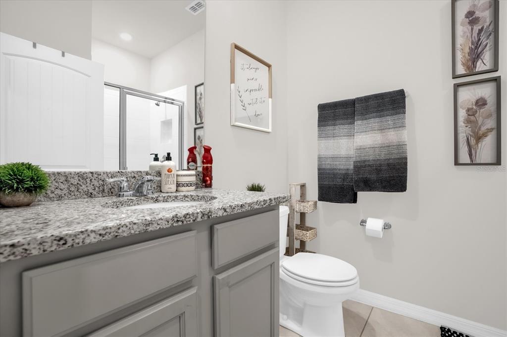 6775 Sarus Crane Point Harmony, FL 34773 - Photo 10 of 28 a bathroom with a granite countertop toilet sink and mirror