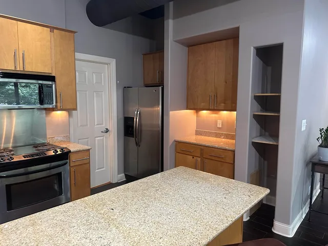 a kitchen with granite countertop a refrigerator stove and oven