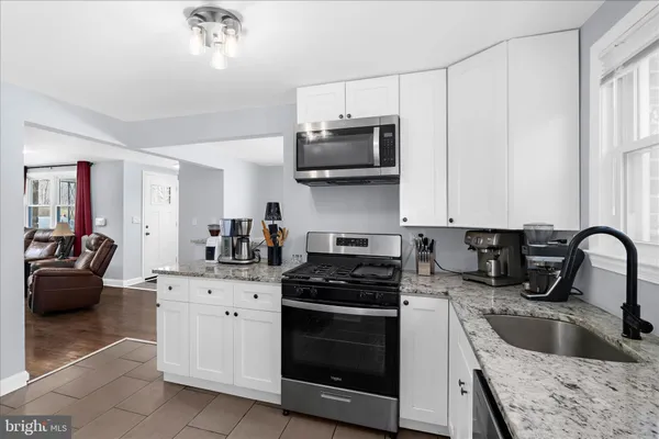 a kitchen with stainless steel appliances granite countertop a sink stove and microwave