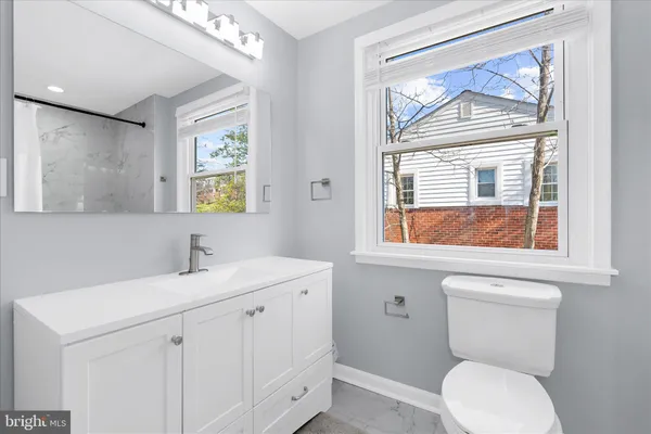 a bathroom with a toilet a sink and a window