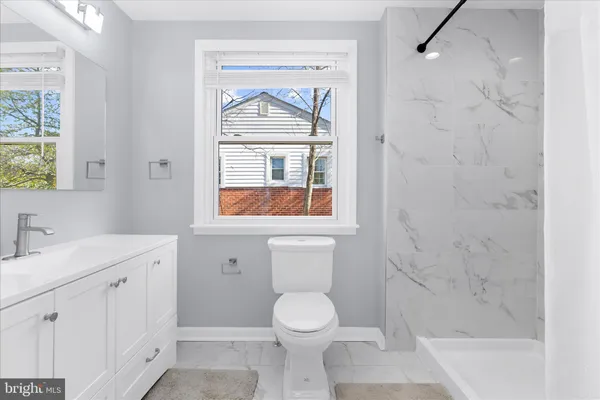 a bathroom with a toilet sink vanity and mirror