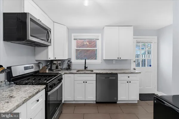 a kitchen with stainless steel appliances granite countertop a sink and a stove